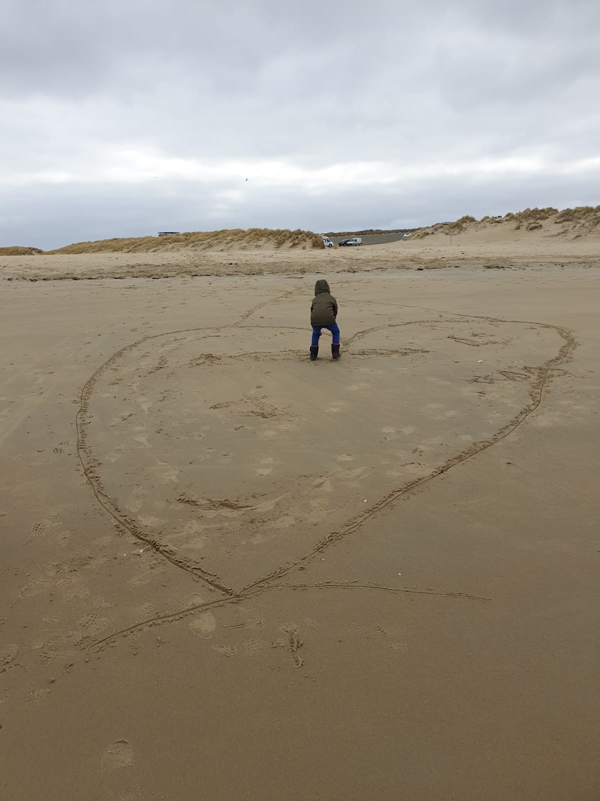 Strand met een hartje in het zand.