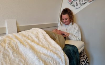 Sanne geeft haar klant, die op de behandelbank ligt, een Access Bars behandeling